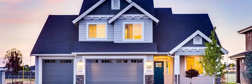 Grey house with grey garage doors and blue front door